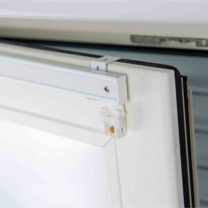 Binario tenda a pacchetto montato sul profilo di una finestra. Si evince come il montaggio non necessiti di fori perchè l'aggancio è direttamente sul profilo della finestra