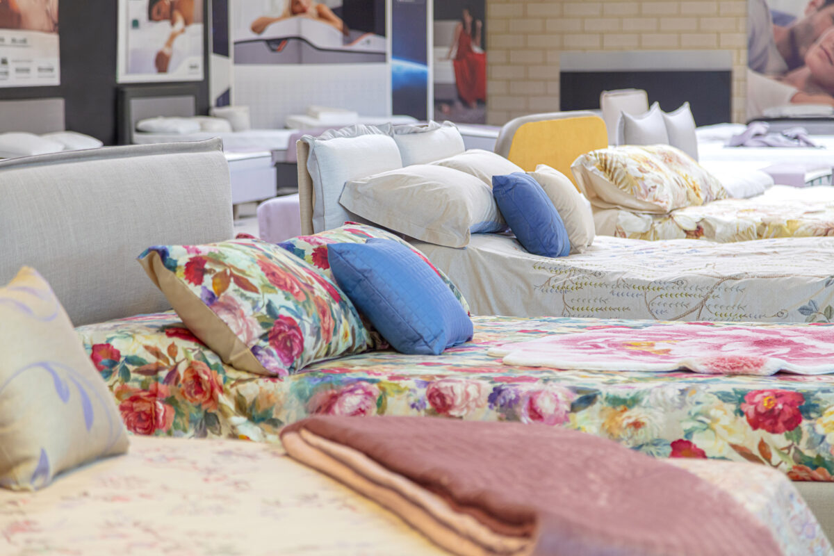 Letti in esposizione con materassi multibrand e completi colorati.
